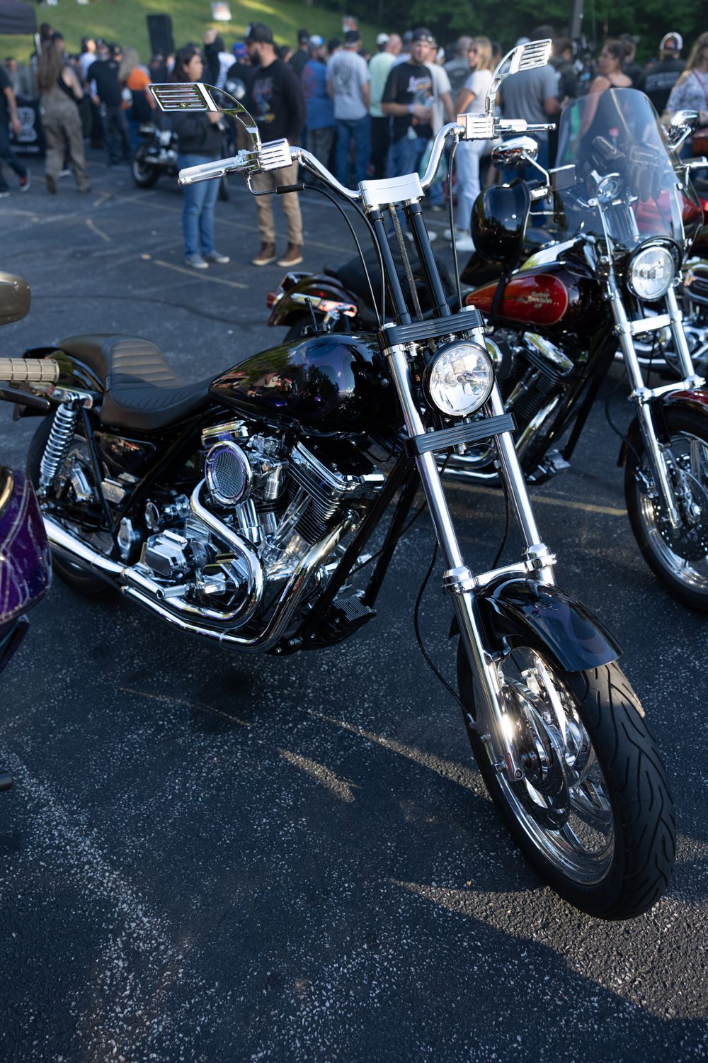 Harley with tall bars parked in front of the crowd at Laconia Harley-Davidson
