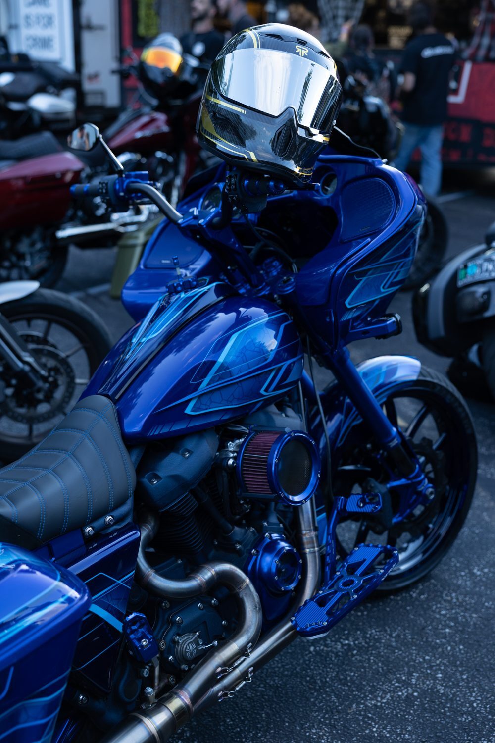 Blue custom bagger with chrome helmet on seat at Laconia Harley-Davidson